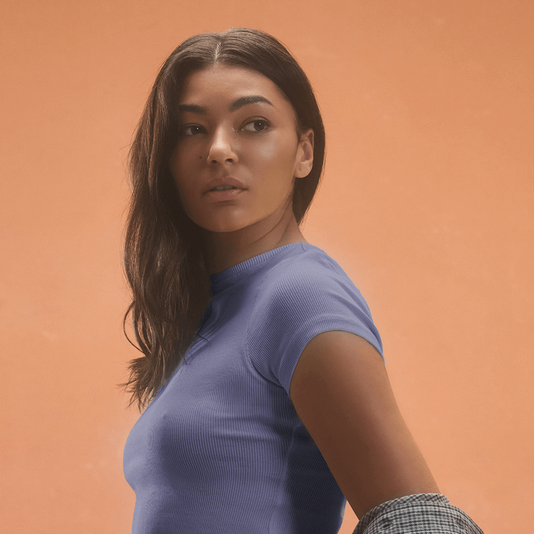 Woman wearing a blue ribbed RIB TEE HERON shirt showcasing stylish casual apparel