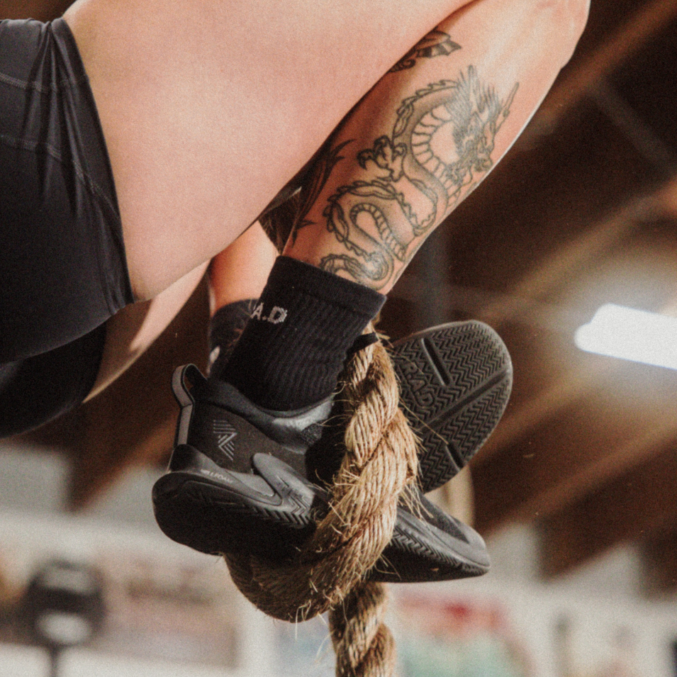 Black athletic shoes on rope.