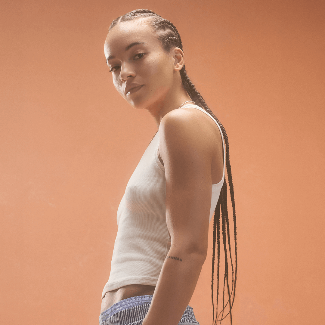 Woman wearing a white rib tank top from the RIB TANK OFF WHITE collection